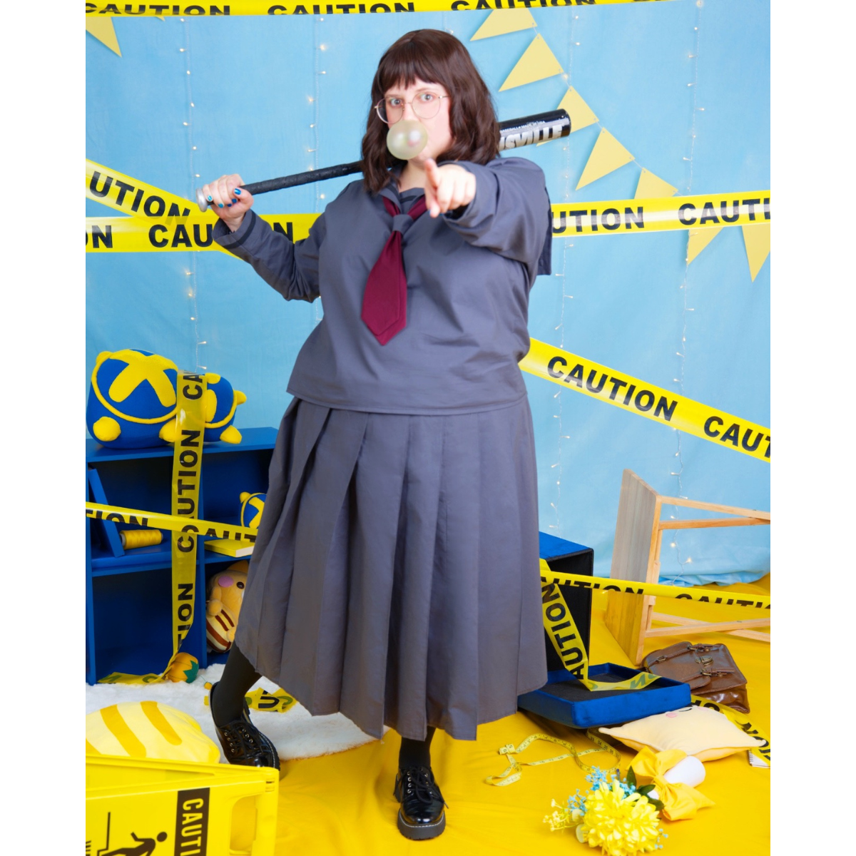 Plus size (size J) model posing in a grey and maroon school uniform, with Pleated Skirt and Sailor Blouse. The sleeves of the blouse and length of the skirt are the long variants for each pattern.