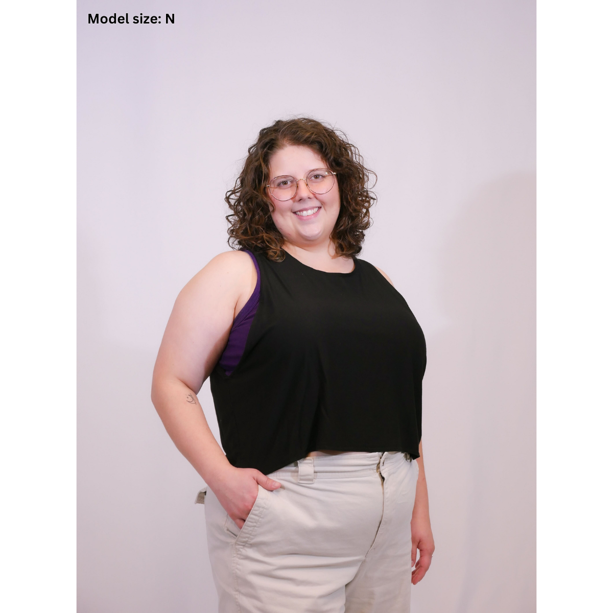 A photo of a person wearing a black sleeveless crop top (Size N) with beige pants.
