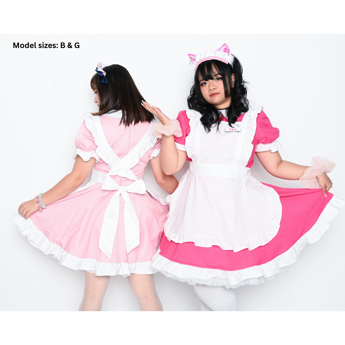 A photo of 2 people wearing maid outfits. The first one is wearing a pink dress with white ruffles and a fully white apron (size B) facing away so you can see the back and criscross ties and bow, the second is wearing a hot pink dress with white ruffles and a fully white apron (size G).