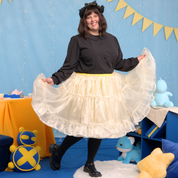 Plus size model (size J) posing with the ends of the petticoat raised in each hand, showing off the volume of the layers.