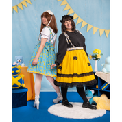 Female models (size C and J), posing in different styles of Lolita Skirt. The model on the left is facing away from the camera, wearing a duck-themed skirt with yellow pom trim and criss-cross straps in the back. The waist bow is also visible. The model on the right wears a yellow honeybee-themed Lolita Skirt with two layers of lace trim and applique details.