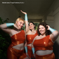 A photo of 3 people all different sizes wearing Stella's orange iconic season 1 outfit. From left to right top size F / bottom size I, size N, and size J.