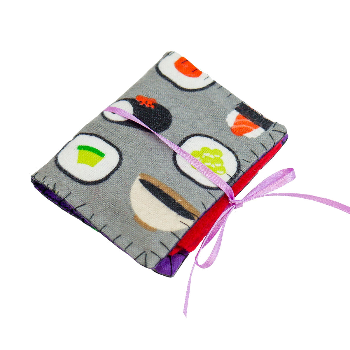 A single completed Needle Book with sushi patterned fabric on the outside, red felt pages on the inside, and a thin light pink ribbon tying it closed around with a bow.