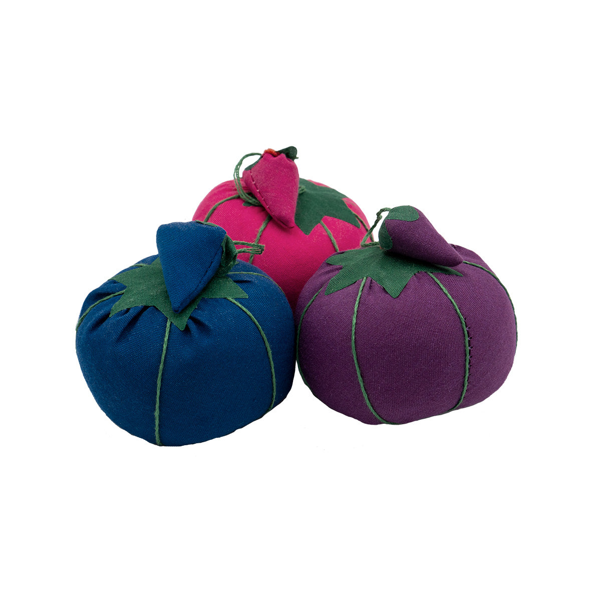 Three tomato-shaped pin cushions are arrayed in a triangle. The left cushion is blue, the top cushion is hot pink, and the right cushion is purple. All have a strawberry-shaped emery attached in the corresponding color.